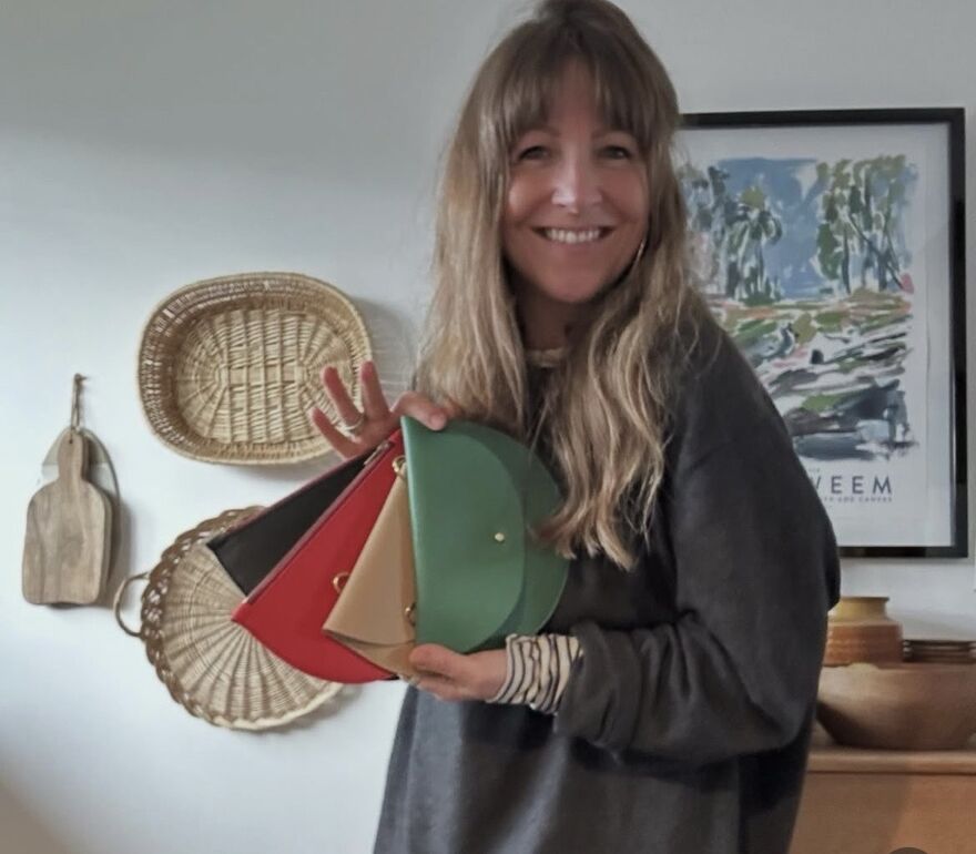 Jude Gove holding examples of her leather accessories