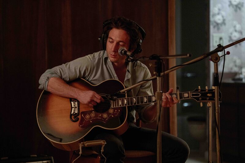 A man plays the acoustic guitar in a recording studio