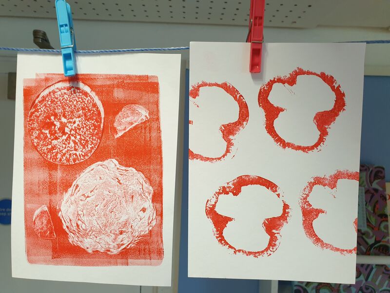 Two prints made using vegetables hanging up to dry