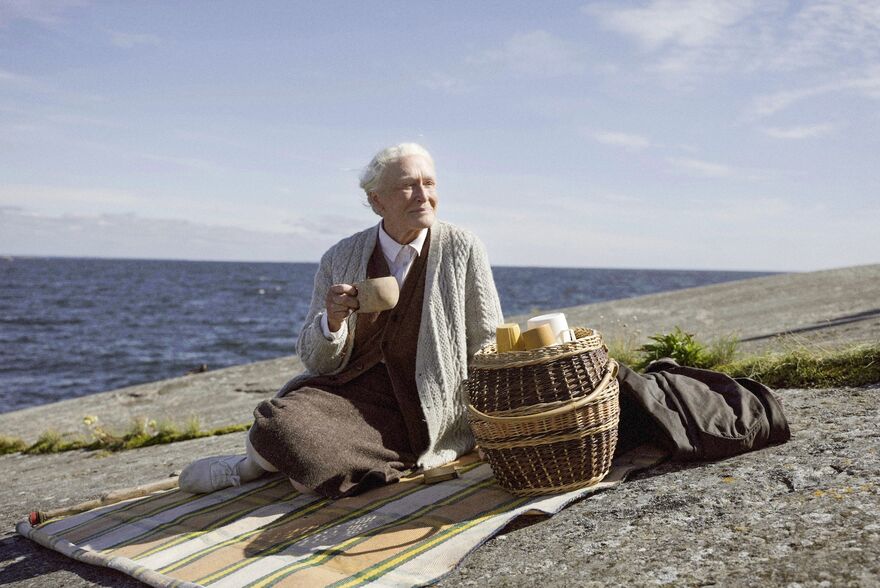 Glenn Close sits on a picnic blanket by the sea