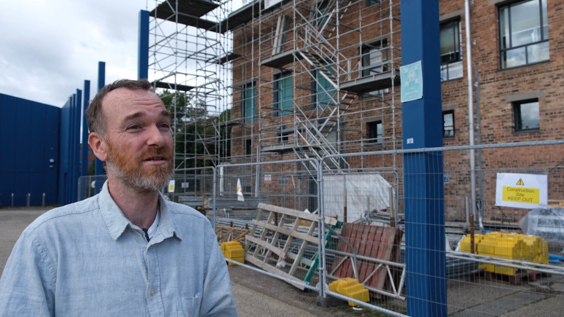Adrian Murray stands outside DCA where scaffolding has been constructed around the building