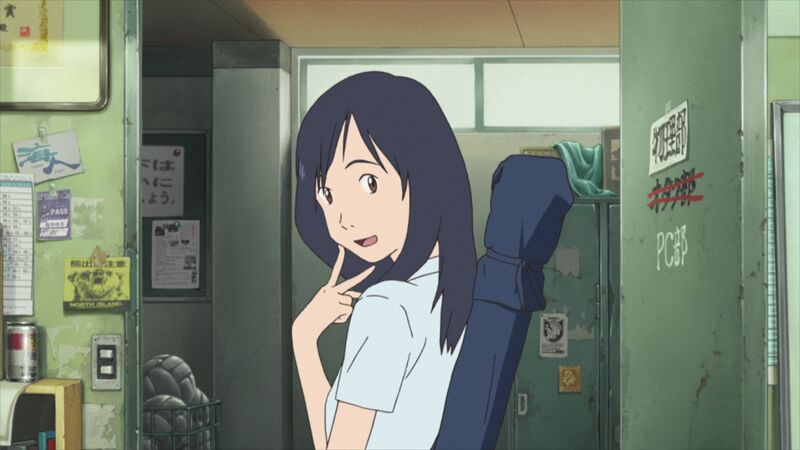 An anime still shows a girl sitting at a computer chair smiling.