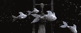 Animated still of fish swimming past a human character
