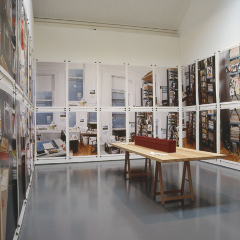 From Allen Ruppersberg's exhibiton at DCA. A plastering table stands in the middle of a room. The room is covered in large posters which recreate another, cluttered room.