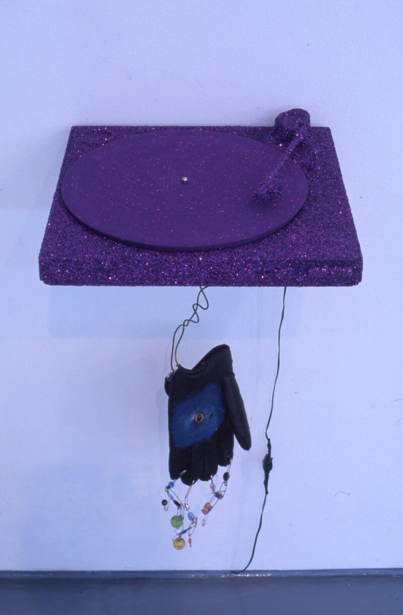 A record player covered in purple paint and glitter.