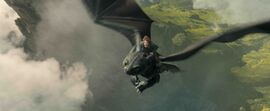 A boy rides through the sky on the back of a black dragon