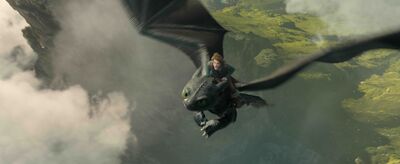 A boy rides through the sky on the back of a black dragon