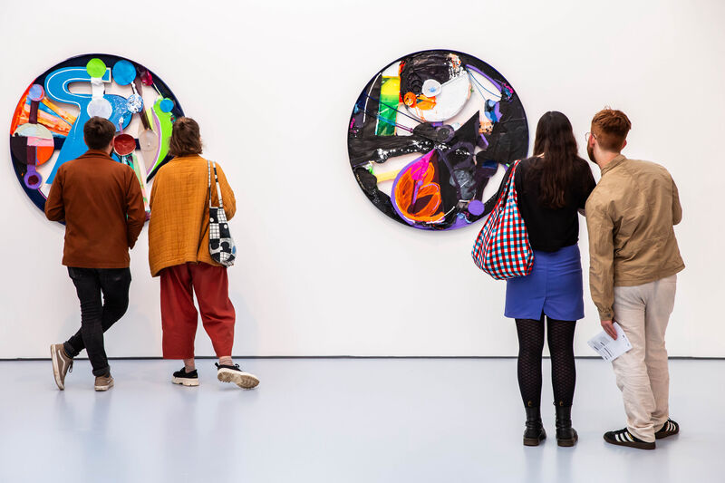 People look at colourful paintings on DCA Gallery walls.