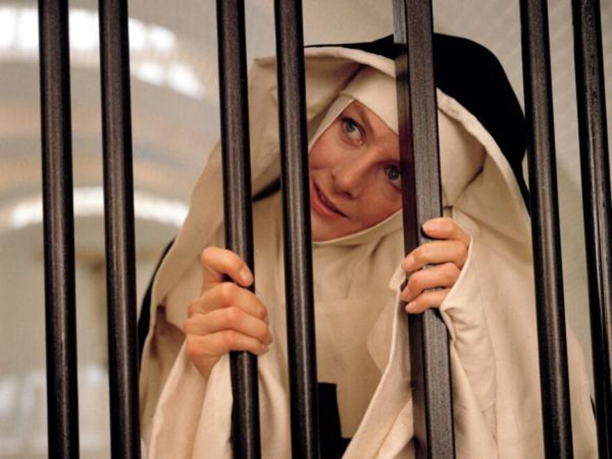A nun holding on to bars