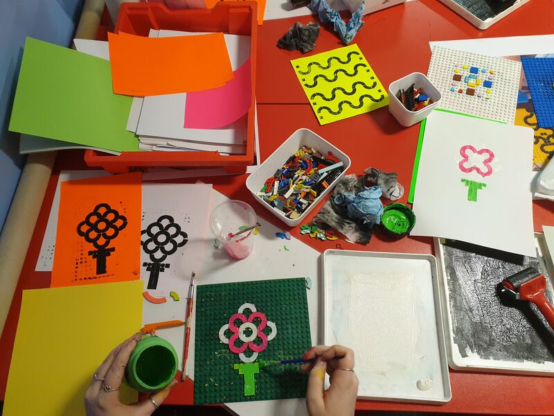 Person adding ink to Lego Dots to make a print of a flower