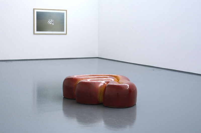 From Richard Deacon's exhibition in DCA Galleries. There is a red, curved sculpture on DCA Gallery floors.