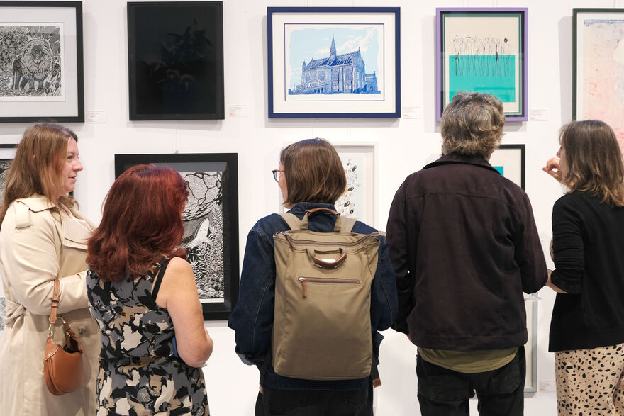 People looking at prints on the walls of DCA Centrespace