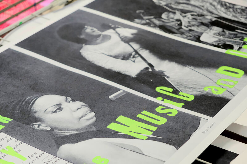 black and white screen print of singers with green text