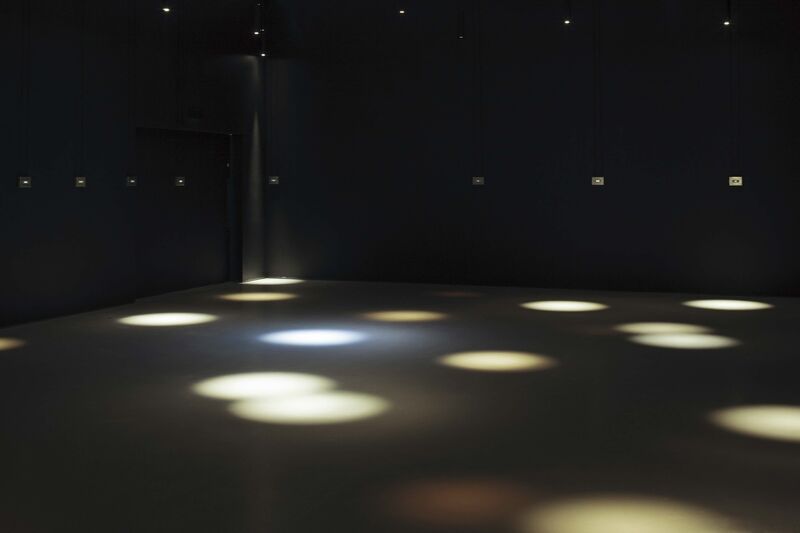 From Jim Campbell's exhibition. In a dark room, spotlights are projected on to the floor.