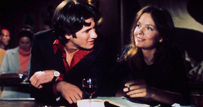 Diane Keaton sitting in a bar looking to the side