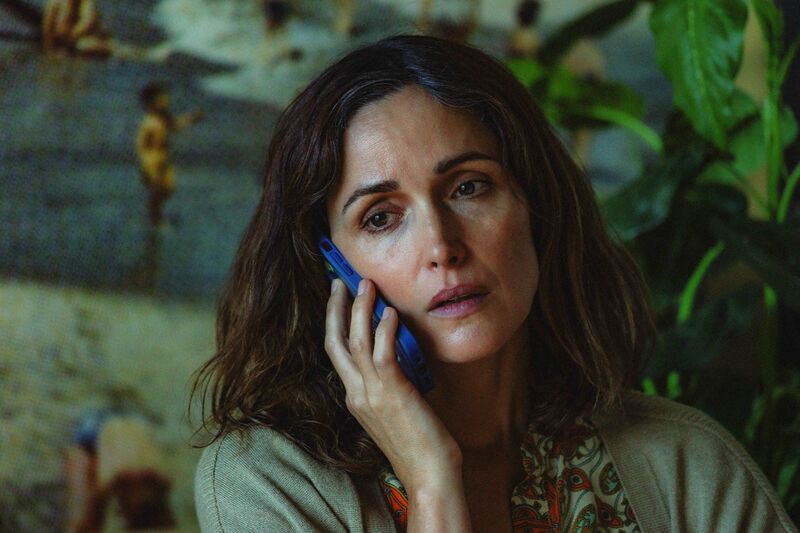 A tired-looking woman talks on the phone