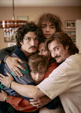 A family of four hugs and smiles