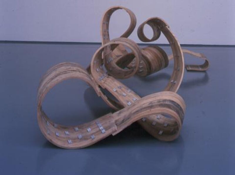 From Richard Deacon's exhibition in DCA Galleries. A sculpture lies on the gallery floors. It is made out of tightly curled wooden ply wood.
