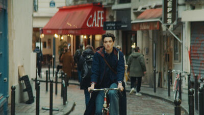 A young woman cycles her bike through the cobbled streets of Paris.
