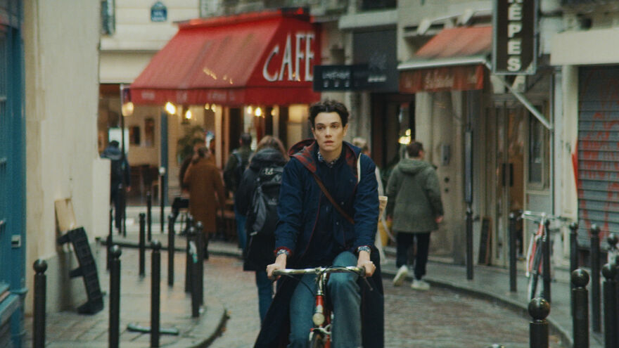 A young woman cycles her bike through the cobbled streets of Paris.