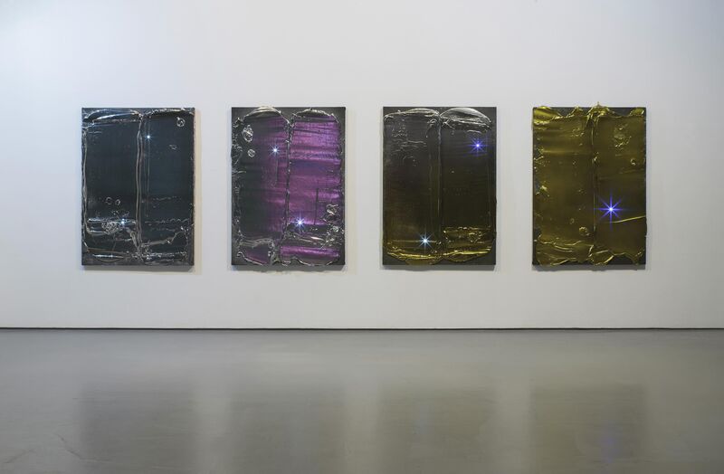 From Florian & Michael Quistrebert's exhibition. Four rectangular canvases are covered in shiny, metallic material. There are bright, star-like sparkles on the canvases.