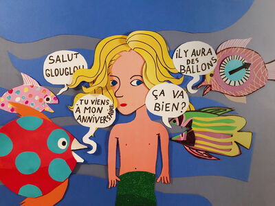 Papercut image of a young mermaid surrounded by fish.