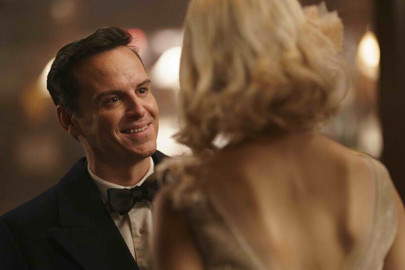A man in a suit and bow tie smiles at a blonde woman