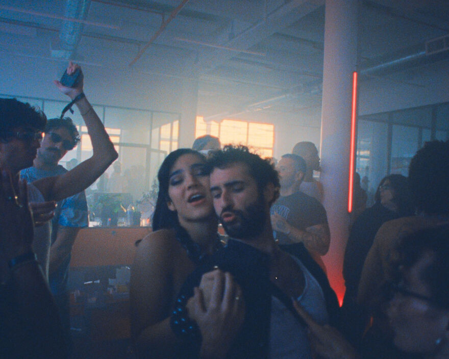 A woman and a man film themselves at a party