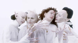 Three vampires with pointy ears surround a woman with a cross on her head