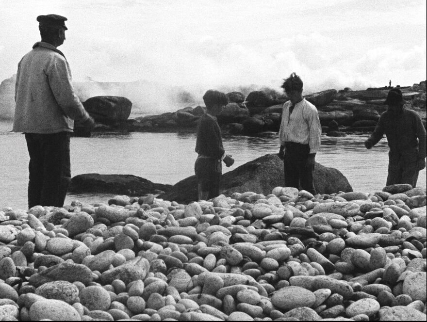 Men and boys on a rocky shore