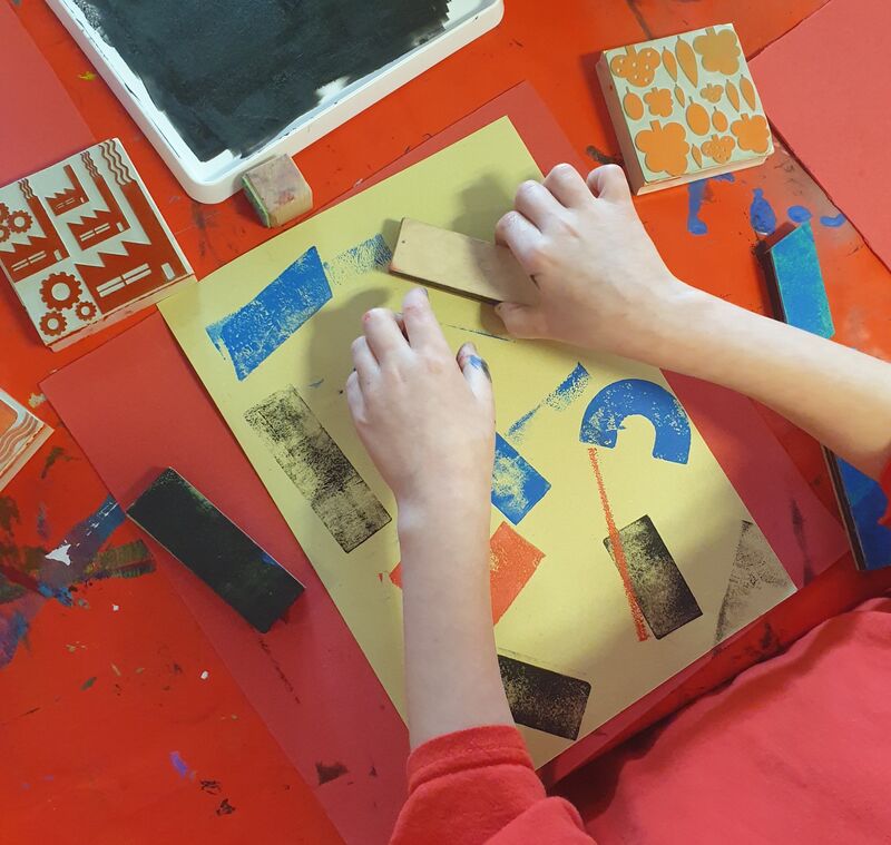 Child making an artwork using stamps