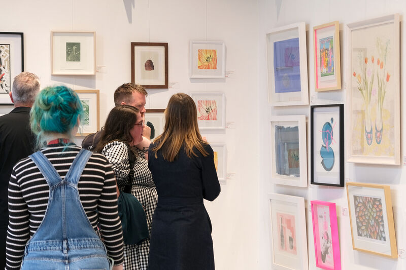 People looking at framed artworks