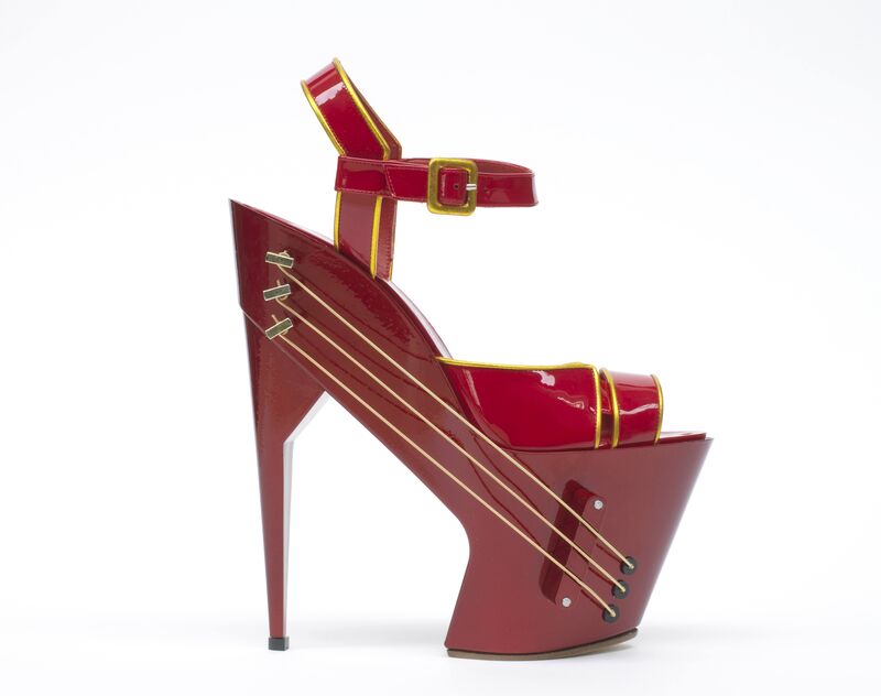 A close up image of the world’s first wireless high-heeled shoe guitar, which is red and has a very high heel.