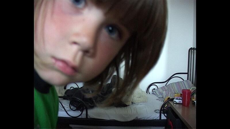A young boy looks into the camera