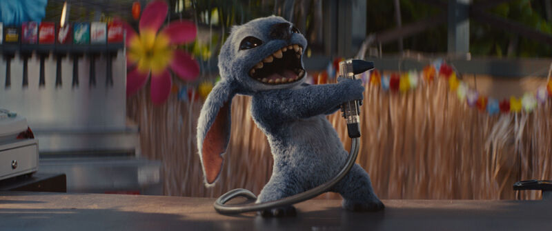 Stitch, a cute blue fluffy alien, dances on top of a bar.