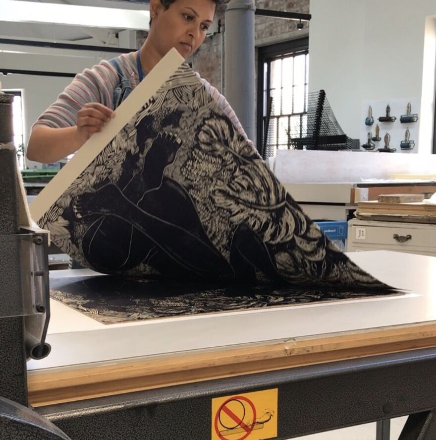 Photo of Anupa Gardiner working on a large print  of a figure