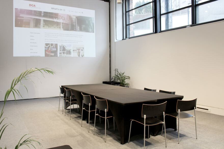 The Centrespace is set up with a table for 10 people. The projector screen shows a website.