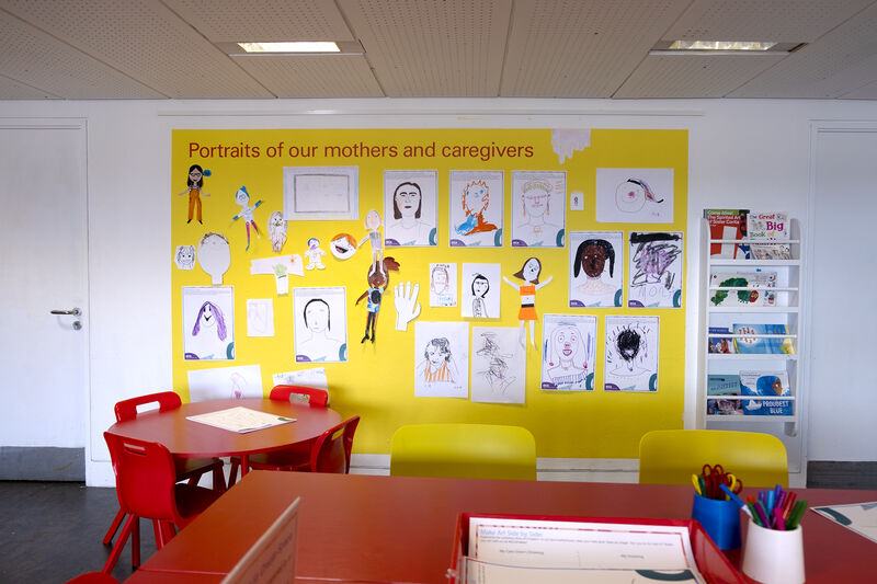 Wall of Create Space decorated with portraits of mothers and caregivers