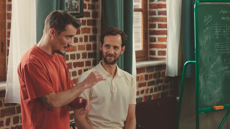A man talks to another man in classroom.