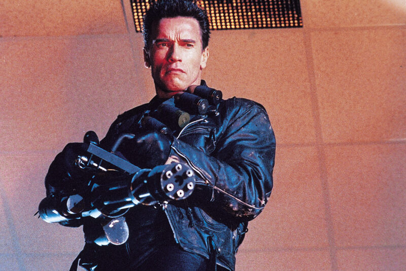 A man aims a giant minigun 