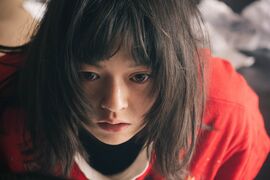 Woman wearing a red top with a worried expresion