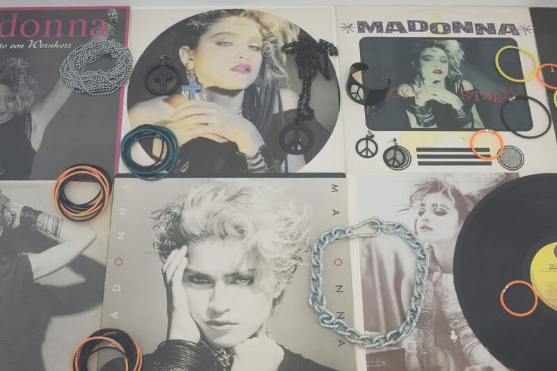 From the exhibition 'Spring Summer 2015', a top-down display of pictures Madonna. Neon hair bobbles are laid on top of the pictures, along with earrings.