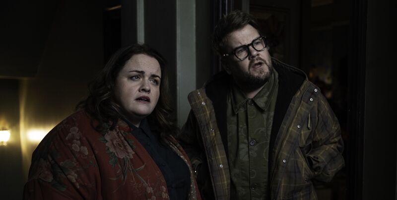 A woman is told to the left and a man to the right looking confused and surprised at something out of shot