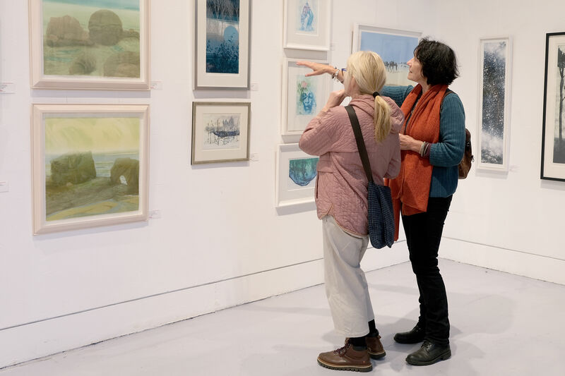 People pointed at framed artwork