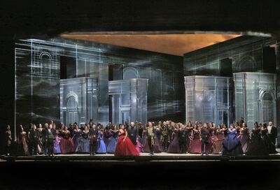 A huge company of singers in beautiful gowns on stage.