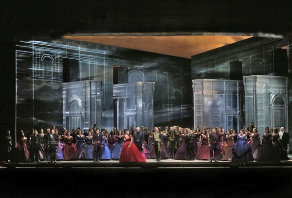 A huge company of singers in beautiful gowns on stage.