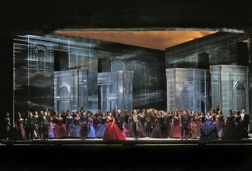 A huge company of singers in beautiful gowns on stage.