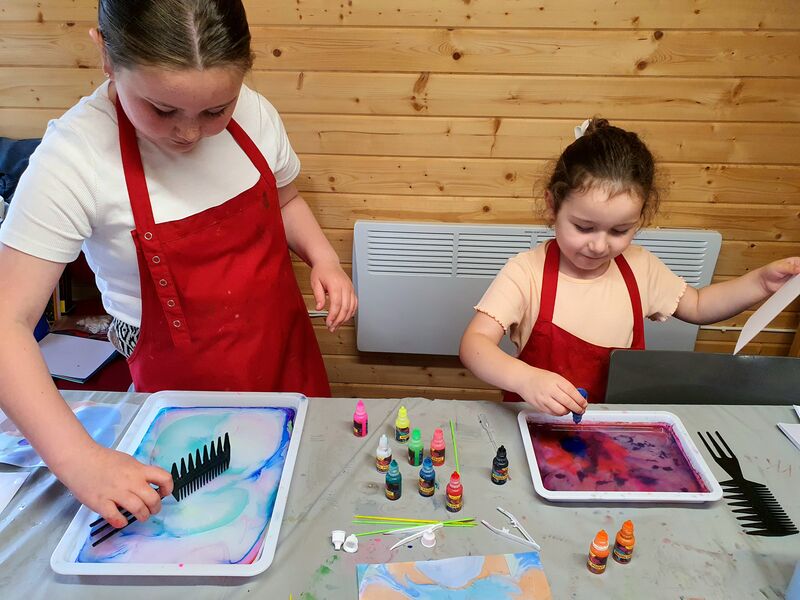Two children doing paper marbleing