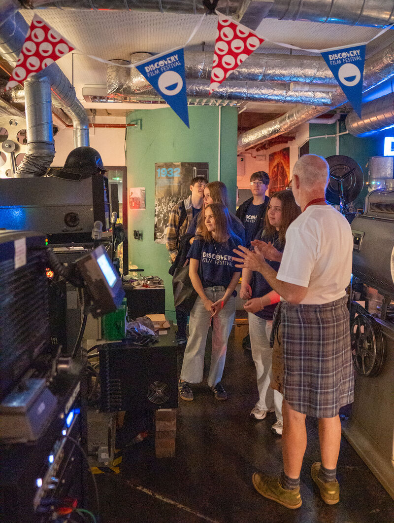 A group of young people enjoy a tour of DCA's projection booth
