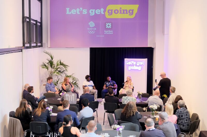 A Royal Bank of Scotland conference takes place in DCA Centrespace. People sit at round tables watching a panel of four speakers.